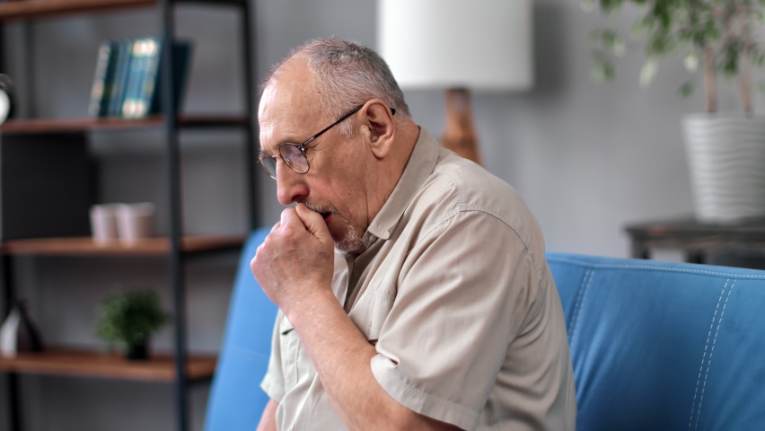 Unwell grandfather elderly man coughing sickness influenza symptoms sitting on couch at home closeup. Aged 70s male suffer throat pain covid flu disease chronic allergic bronchial pneumonia | Shutterstock HD Video #1093074757