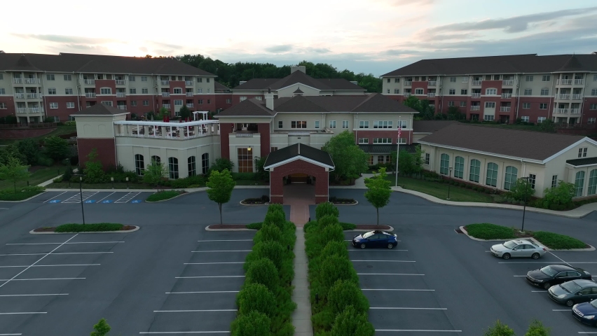 Retirement community complex in America. Multiple assisted living homes for the elderly. Rising shot of campus at sunset. Royalty-Free Stock Footage #1093080557