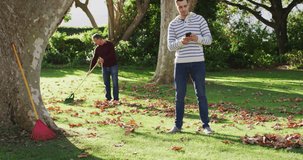 Video of happy caucasian senior father and adult son gardening and looking at smartphone. Family, domestic life and togetherness concept digitally generated video.