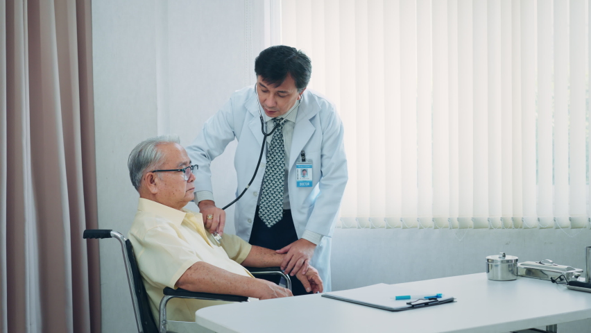 Asian male doctor hold stethoscope listen to elderly patient heart in hospital. | Shutterstock HD Video #1093095677