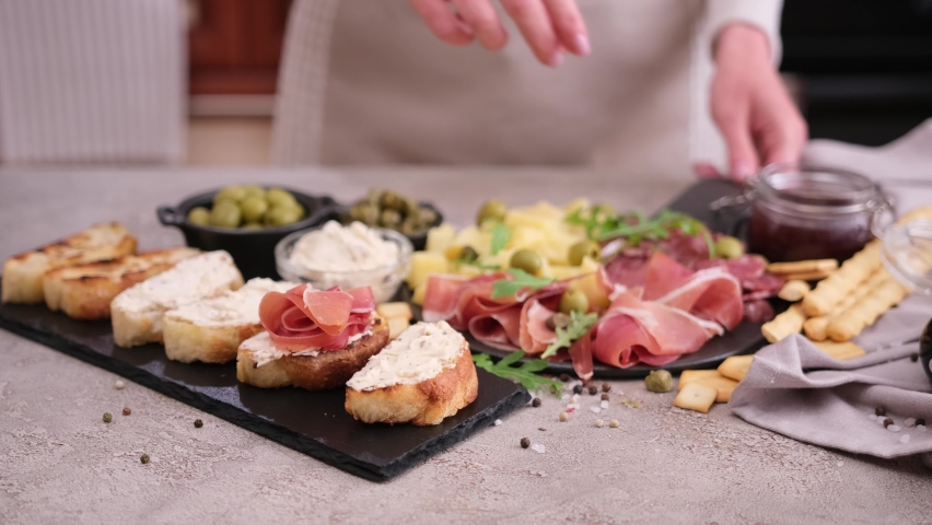 Making bruschetta with prosciutto or jamon ham at domestic kitchen | Shutterstock HD Video #1093096605
