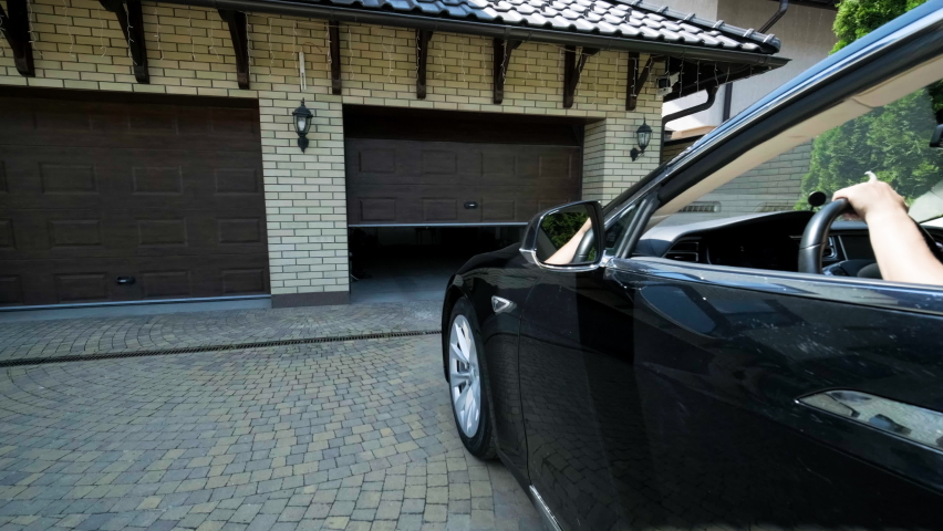 Man driver in car thumbed remote control to open the garage door in the house Royalty-Free Stock Footage #1093097127