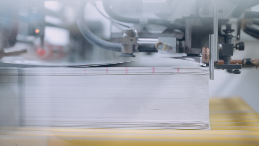 A cutting machine in a printing shop cuts a large pile of printed packaging. Royalty-Free Stock Footage #1093106581