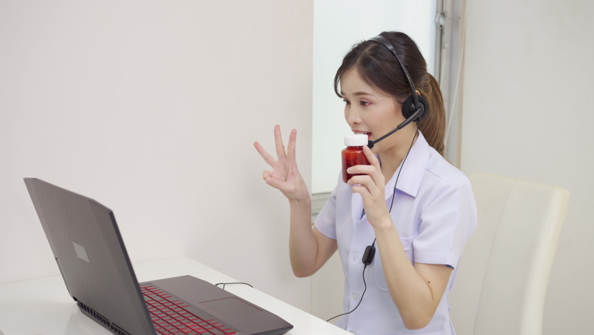 Asian Female doctor wears a headset and uses a laptop to do the talking and give medication instructions to their patient remotely via telemedicine at the hospital. Telemedicine online, communication | Shutterstock HD Video #1093106655