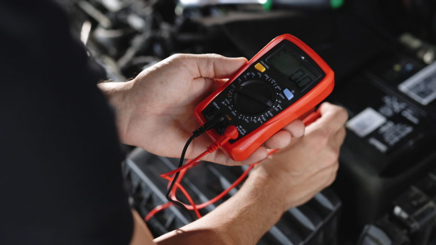 Man using multimeter to measure the voltage of the batteries. Mechanic doing car inspection, he is testing car battery with tester. Check battery voltage with electric multimeter. Royalty-Free Stock Footage #1093108027