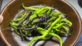 Organic Purple and green village peppers on old wood and hand Macro Detail shot 4K video wonderful natural background images buying now. 