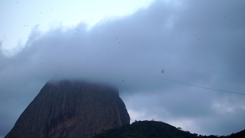Aerial Lockdown Shot Of Cables Cars Moving Towards Famous Mountain Under Dramatic Clouds - Rio de Janeiro, Brazil