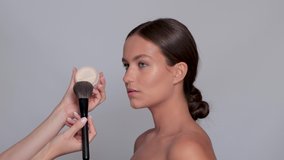 Makeup artist powders the face. Portrait of a beautiful charming brunette girl with beautiful fresh makeup and healthy clean skin. Professional makeup concept - Powered by Shutterstock - Get 15% off with code: PIKWIZARD15