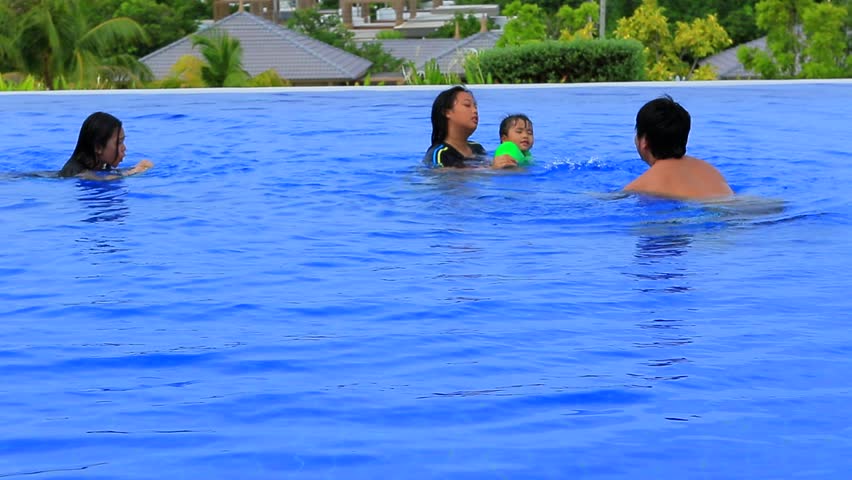 brother family in swimming pool playing and relaxing 