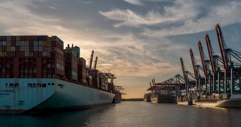 Hamburg,Deutschland - August 2022 : At a large container terminal in the port of Hamburg, container ships are handled during a beautiful sunset 