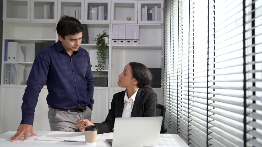 Concept of experienced and competent coworker, employer, supervisor giving advice to a young female office worker. Teamwork between coworkers, leadership company, multiracial in workspace. | Shutterstock HD Video #1093132927