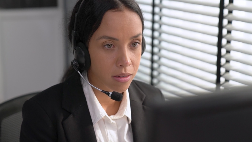 Competent african american female operator working on computer and while talking with clients. Concept relevant to both call centers and customer service offices. | Shutterstock HD Video #1093132993