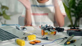 Asian kid boy assembling board into Arduino robot car homework, Little child assemble DC to DC converter into car toy, creating electronic AI technology workshop online school lesson - Powered by Shutterstock - Get 15% off with code: PIKWIZARD15