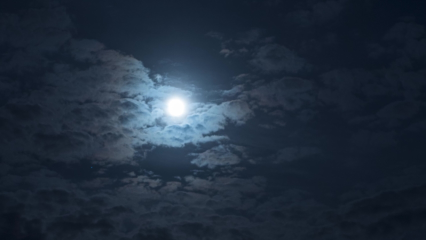 A mysterious night sky with clouds and a full moon. Nighttime timelapse. Clouds cover and reveal the moon | Shutterstock HD Video #1093136527