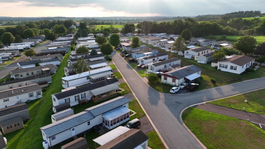 Summer storm rolls in at rural American mobile home trailer park. Low aerial above low income housing. Poverty in USA theme. Royalty-Free Stock Footage #1093138065