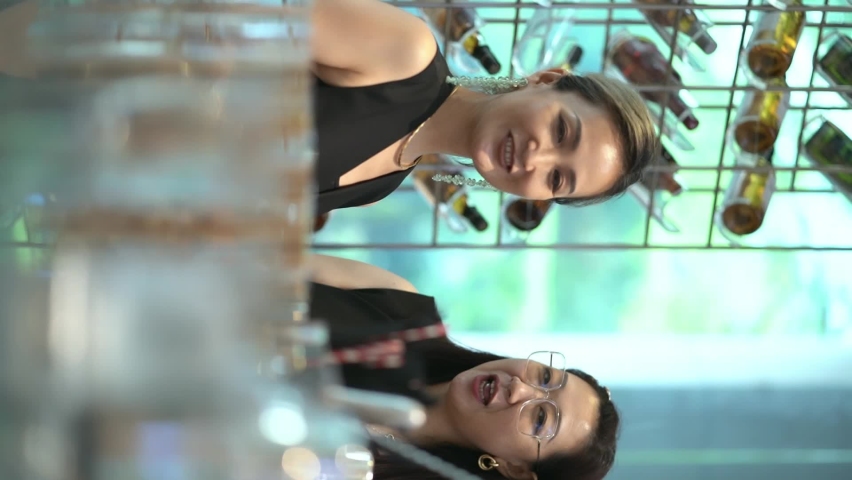 Two Asian women sitting at bar counter talking and laughing | Shutterstock HD Video #1093141805
