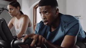 Fit, happy black male adult cycling in group cycle class at an indoor fitness gym. - Powered by Shutterstock - Get 15% off with code: PIKWIZARD15