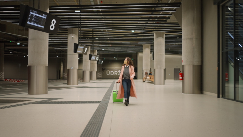 Young woman traveler going bus station with luggage.