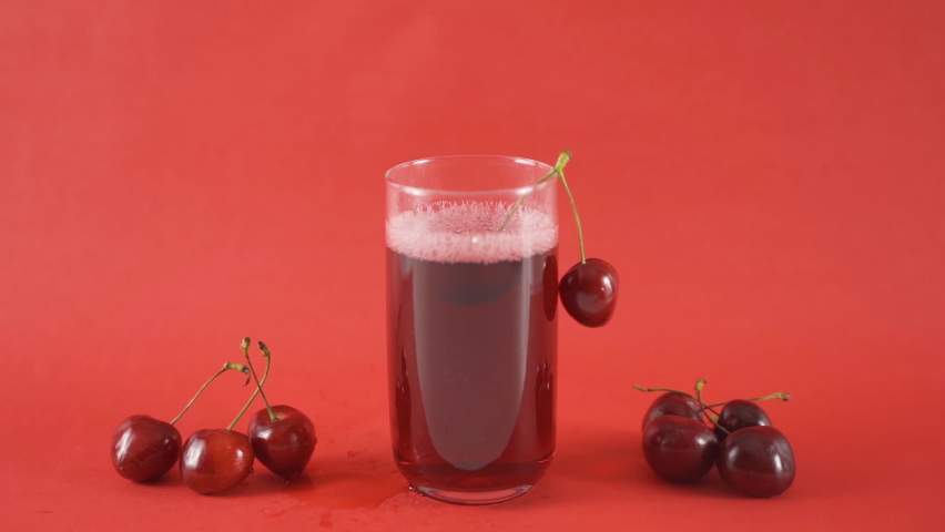 Cherry juice in a glass.
Slow motion video. Cherry juice in a rotating glass and cherries hanging from the rim of the glass.
 Royalty-Free Stock Footage #1093148997
