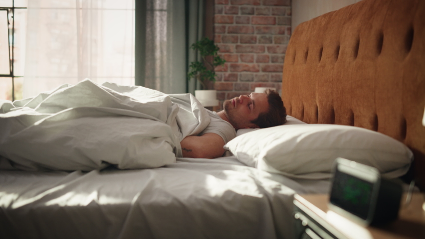 Handsome Young Man Waking up in the Morning, Stretches and Gets Out of Bed, Sun Shines From the Apartment Window in Bedroom, He is Ready for Business Opportunities, Achievements, Adventures Royalty-Free Stock Footage #1093149607