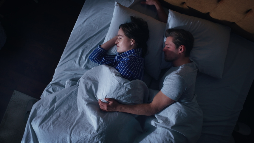 Top View Home: Happy Young Couple Cuddling Together in the Bed Sleeping at Night. Beautiful Girlfriend and Handsome Boyfriend Sleeping Together. Family of two Sweetly Embracing Each other. Top Down Royalty-Free Stock Footage #1093149623
