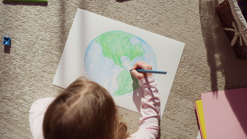 Top View: Little Girl Drawing Our Beautiful Planet Earth. Very Talented Child Having Fun at Home, Imagining Our Home Planet as a Happy Place with Clean, Sustainable Living. Cozy Sunny Day. Zoom out Royalty-Free Stock Footage #1093149757