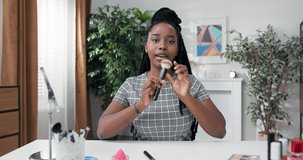 Intro video to help choose right makeup accessories. Woman records beauty tutorial on social media. Girl demonstrates softness of powder brush bristles extends hand to camera catch focus.