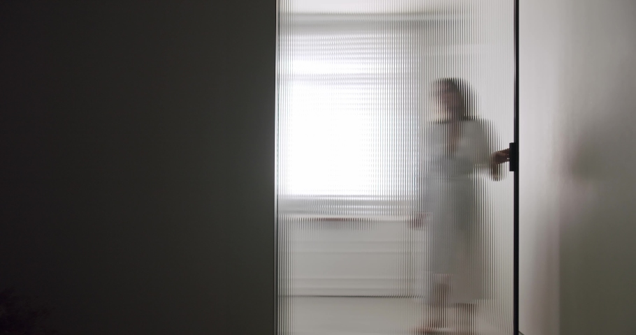 Woman in robes open Transparent sliding door inside the modern bathroom, minimalist bathtub with wood accessories in white and white colors. Modern Minimalist White Bathroom. white minimalist Royalty-Free Stock Footage #1093156131