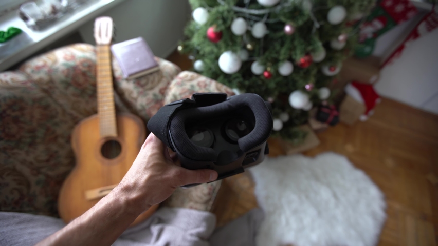 3d glasses watching virtual reality in headwear near xmas tree