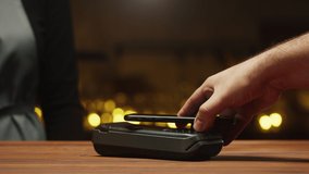 Paying with smartphone close-up. Cashless shopping in restaurant or cafe. Touch-free and contactless payment concept. NFC technology and bank terminal. - Powered by Shutterstock - Get 15% off with code: PIKWIZARD15