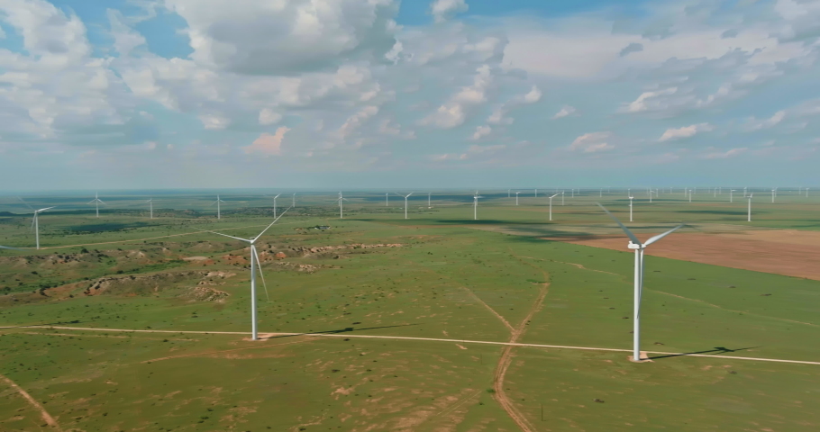 On wind electricity farm in Texas, U.S., one can see a row of windmill turbines which produce renewable green energy. | Shutterstock HD Video #1093172093