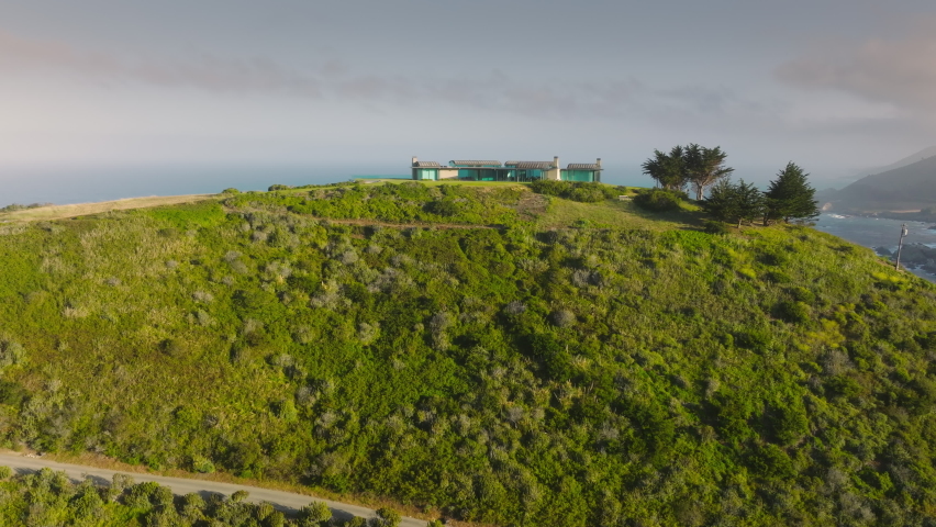 Large contemporary design house with garden and scenic views on west coast of Pacific ocean, California USA. Amazing views on luxury property, real estate business background, 4K aerial drone view 