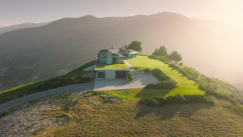 Large contemporary design house with garden and scenic views on west coast of Pacific ocean, California USA. Amazing views on luxury property, real estate business background, 4K aerial drone view 