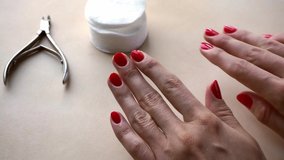 Female hands with red manicure on beige background