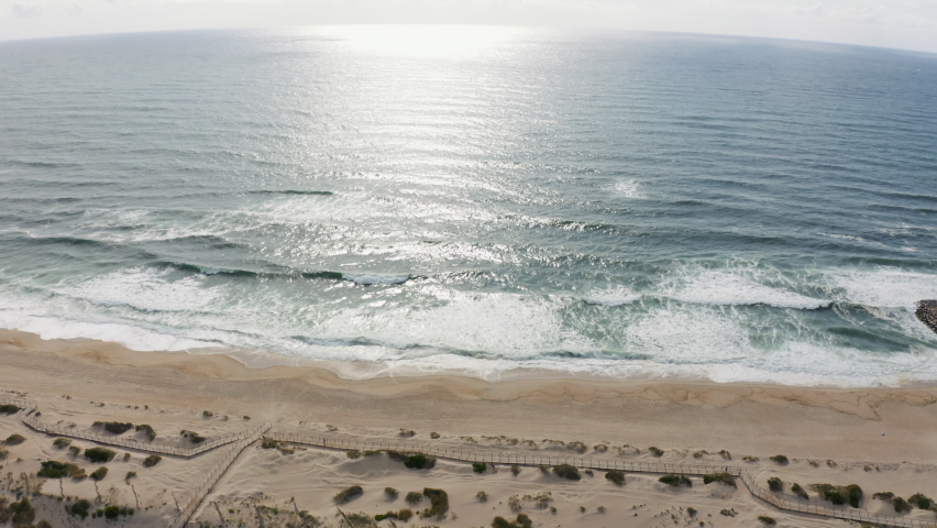 Aerial view over waves at the Praia da Costa Nova beach, in Aveiro, Portugal - tilt, drone shot | Shutterstock HD Video #1093175685