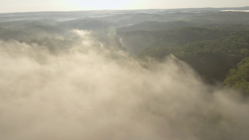 Tilting drone shot of fog hanging over the hills of Oak Hills, West Virginia