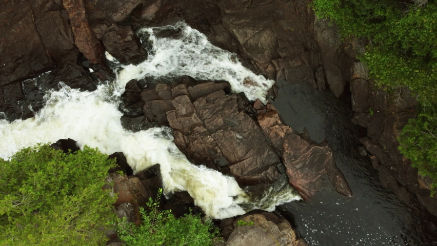 High angle birds eye view of the glory of thundering whitewater rushing down serene rock chutes creating spectacular waterfalls at Oxtongue River Falls, Algonquin provincial park, Ontario, Canada.
