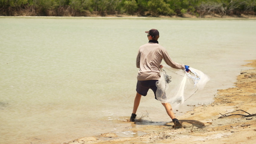Young Fisherman Tossing Casting Net For Fishing Bait In Australian Creek, 4K Slow Motion
