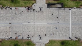 Top down drone video of a group of people in the middle of a park walking around in a circle excersising. Recorded in Lima, Peru in park called 