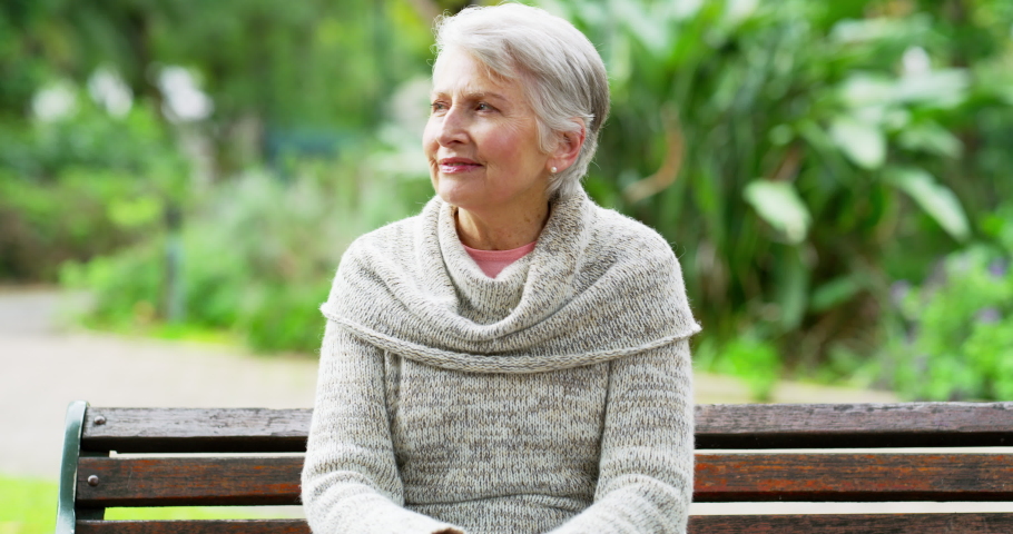 Senior woman suffering from chest pain while sitting outdoors on a park bench. Elderly female having a heart attack outside alone. Mature lady enjoying nature while needing urgent medical attention. | Shutterstock HD Video #1093176889