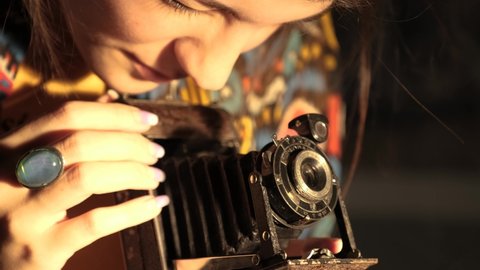 Girl Photographer adjusts retro camera: film stockowy