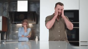 Upset couple stand in kitchen after fight. Realtime. Portrait of sad woman and man having argument at home. Realtime - Powered by Shutterstock - Get 15% off with code: PIKWIZARD15