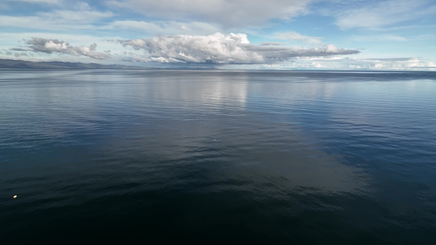 Aerial fly drone view above Titikaka lake, Titicaca lake, lago, South America, Bolivia, Peru, sunny clear blue sky day with beatiful clouds and reflactions. 4k footage.