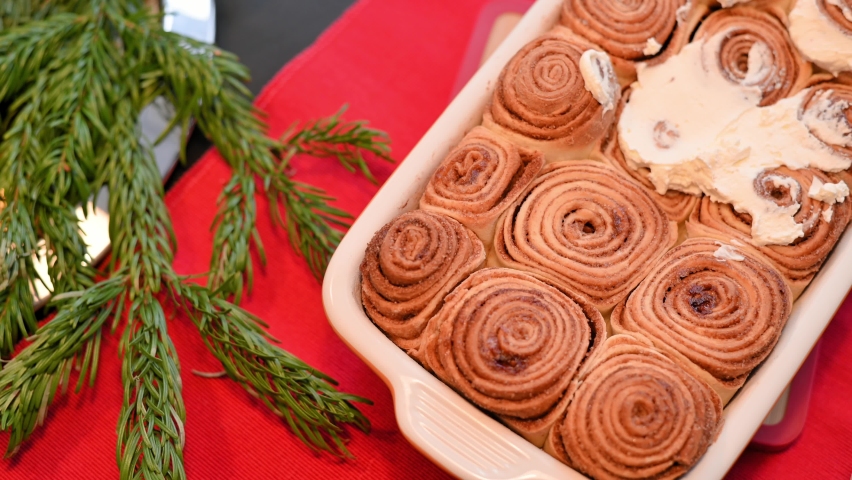 Cinnamon rolls. Cinnabon homemade buns spread with spatula with cheese cream top view. Process of making cinnamon buns at home, fragrant tasty pastry, bakery product. Fresh bakery, sweet dessert | Shutterstock HD Video #1093196057