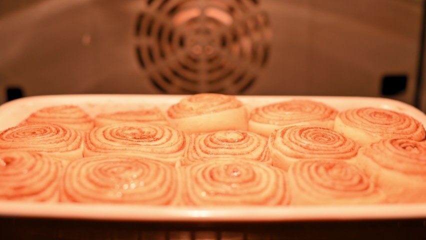 Cinnamon rolls. Cinnabon homemade buns are baked in the oven. The process of making cinnamon buns at home, fragrant tasty pastry, bakery product. Fresh bakery, sweet traditional dessert | Shutterstock HD Video #1093196061