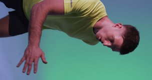 Vertical video of caucasian male tennis player running over neon pink lighting. Sport, movement, training and active lifestyle concept.