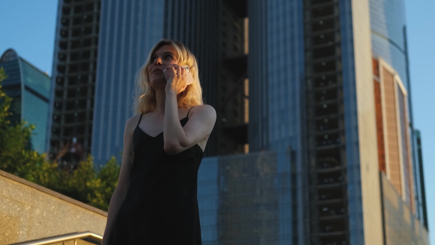Stylish woman talking on the phone on the background of skyscrapers | Shutterstock HD Video #1093207329