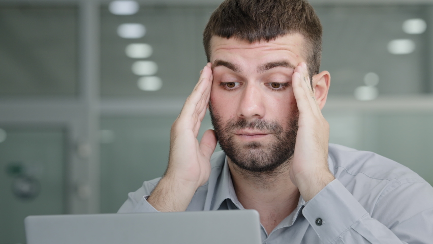 Close-up tired pensive businessman looking at laptop screen suffering from overwork feeling headache painful symptom migraine rubbing temples young sad man sitting in office feels unwell from Royalty-Free Stock Footage #1093217333