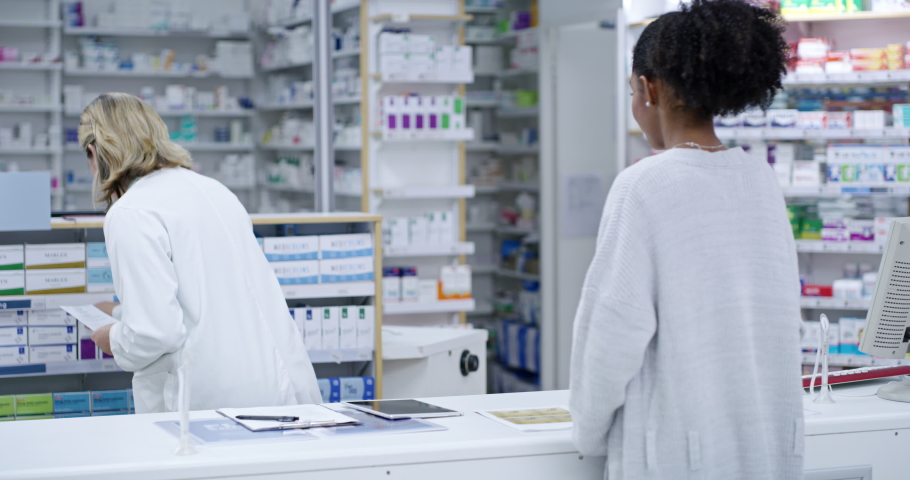 Professional female healthcare pharmacist helping customer buy medicine at the counter in a pharmacy. Woman health consultant or doctor getting medication for patient in a medical clinic store.
