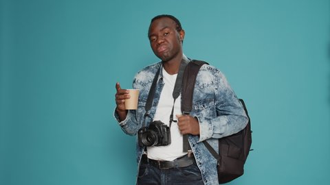 African american man with backpack working as photographer, going on vacation to take professional pictures for production. Model with camera leaving on holiday trip, capturing photos.